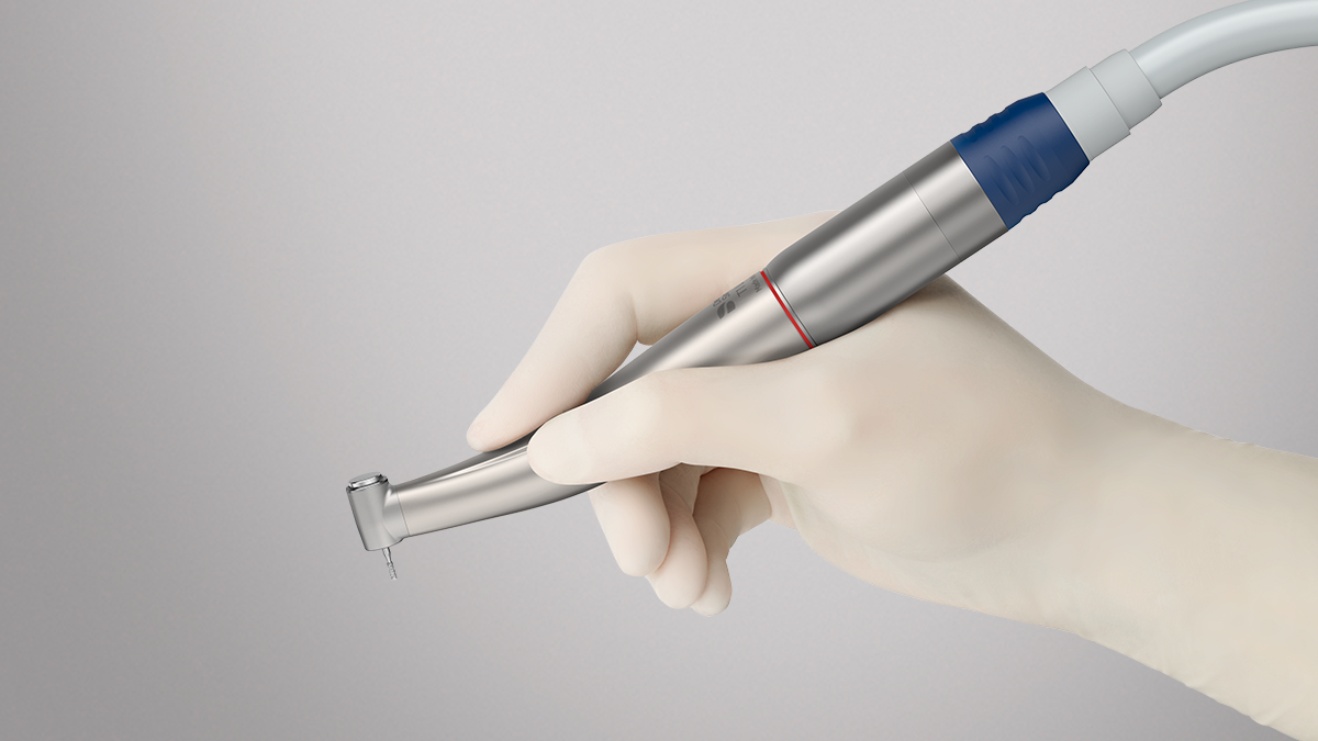 Hand holding Dentsply Sirona dental handpiece